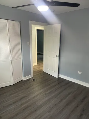an empty room with wooden floor and closet