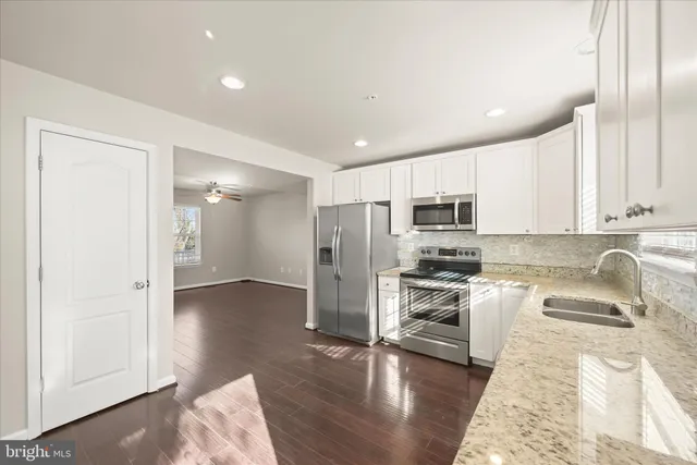 a kitchen with stainless steel appliances granite countertop a refrigerator and a sink