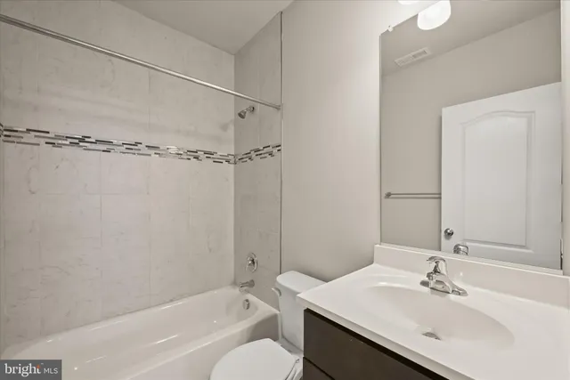 a bathroom with a sink vanity mirror and toilet