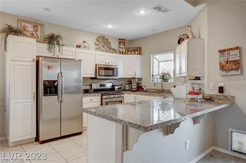 987 Cutter Street Henderson, NV 89011 - Photo 5 of 17 A well-appointed kitchen features stainless steel appliances and abundant granite counter space, ideal for culinary creations.