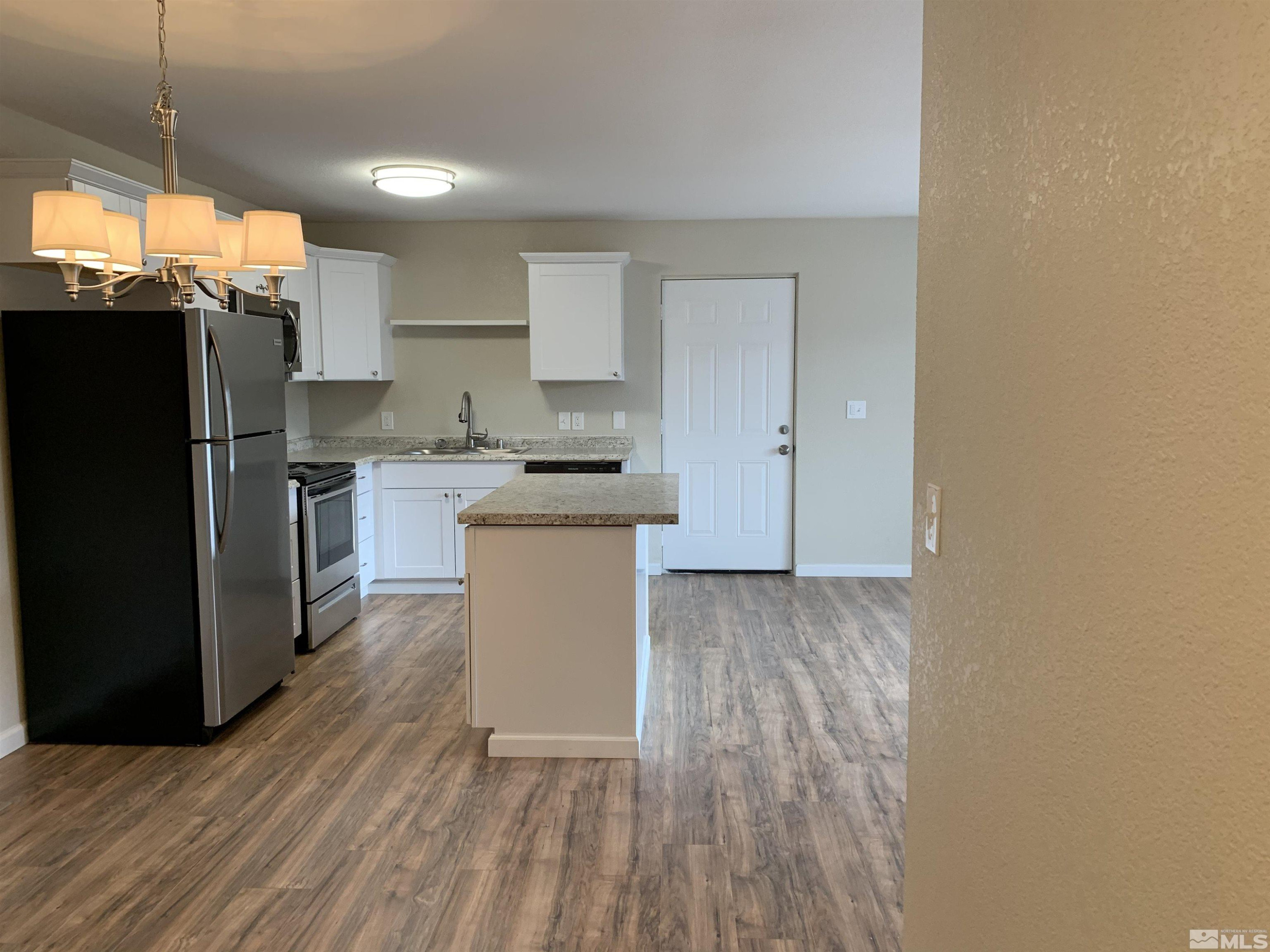 2150 Sutro Street, Unit A3 Reno, NV 89512 - Photo 2 of 8 a kitchen with stainless steel appliances a refrigerator and wooden floor