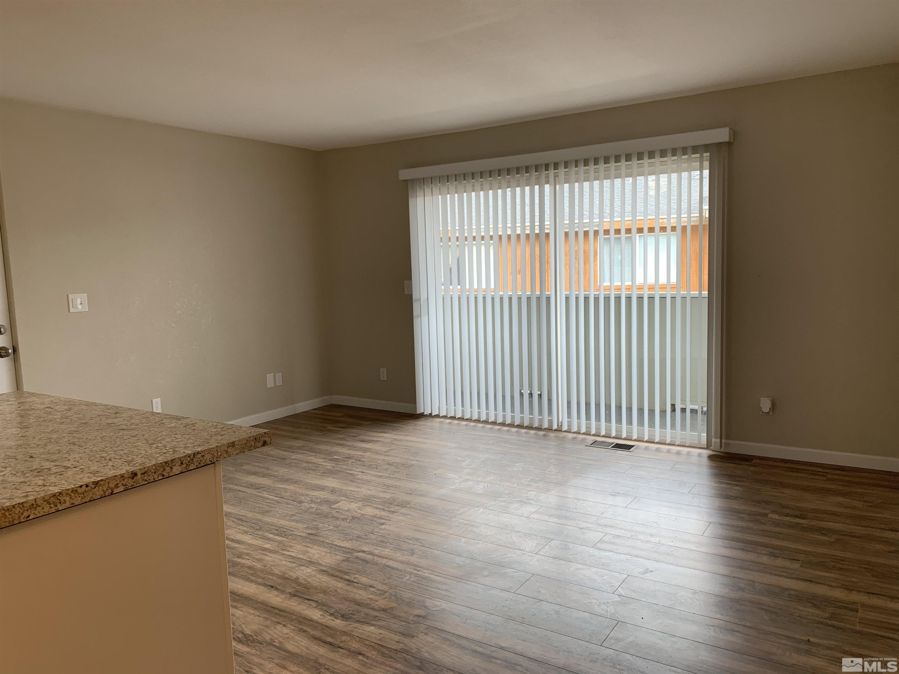 2150 Sutro Street, Unit A3 Reno, NV 89512 - Photo 4 of 8 a view of an empty room with wooden floor and a window
