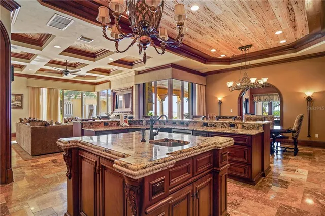 a living room with furniture a large window and chandelier