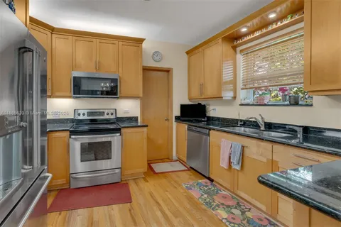 a kitchen with granite countertop a stove a sink and a microwave