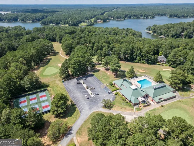 an aerial view of residential house with outdoor space and trees all around