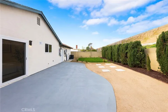 a view of a house with backyard and a trees