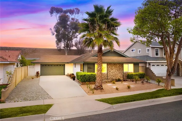 a front view of a house with a yard and potted plants