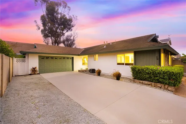 a front view of a house with a garden and yard