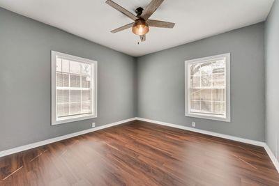 930 Freeman Street Sherman, TX 75092 - Photo 15 of 18 Spacious room featuring rich wood-finish flooring, light gray wall paint, and white baseboards