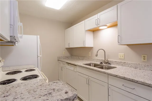 a kitchen with a sink a stove and cabinets