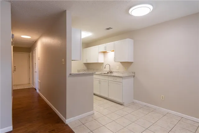 a room with a sink and a view of kitchen