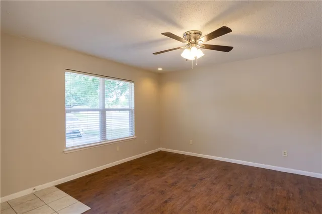 an empty room with windows and fan
