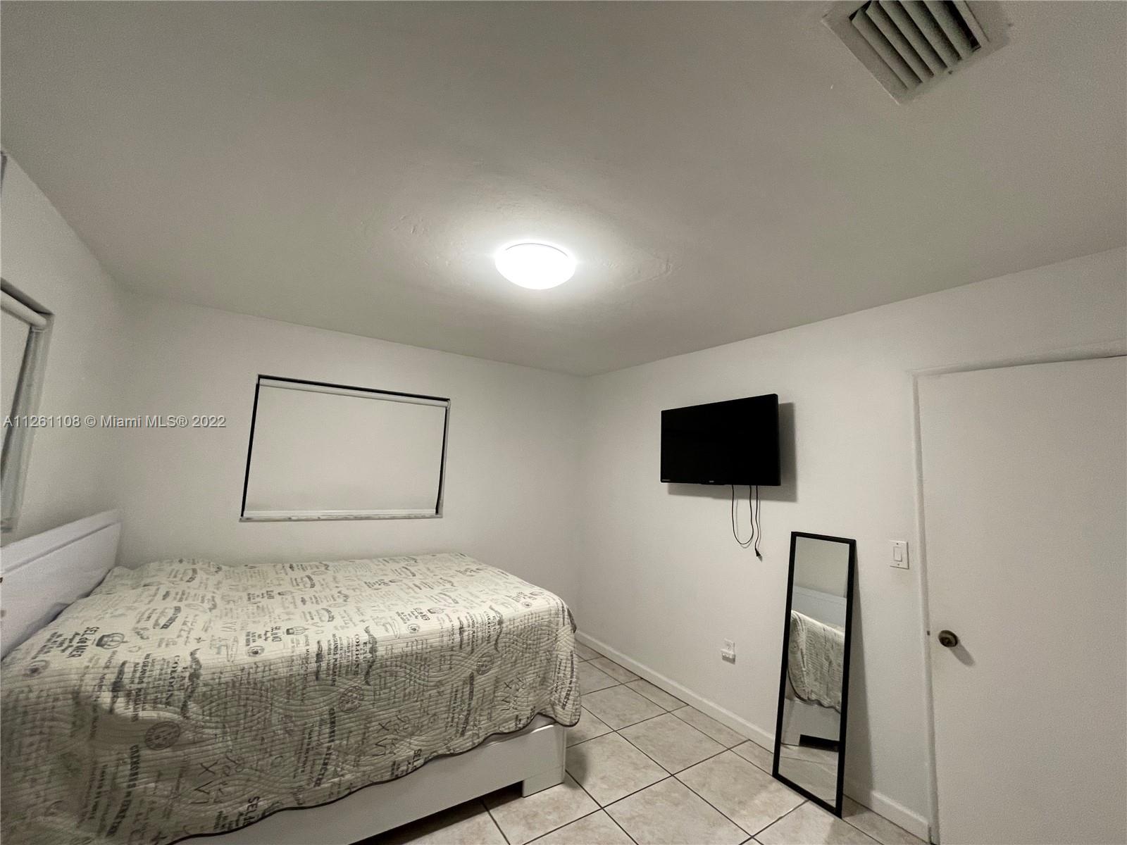 Kendale Lakes Miami, FL 33183 - Photo 17 of 26 a bedroom with a bed and a flat screen tv