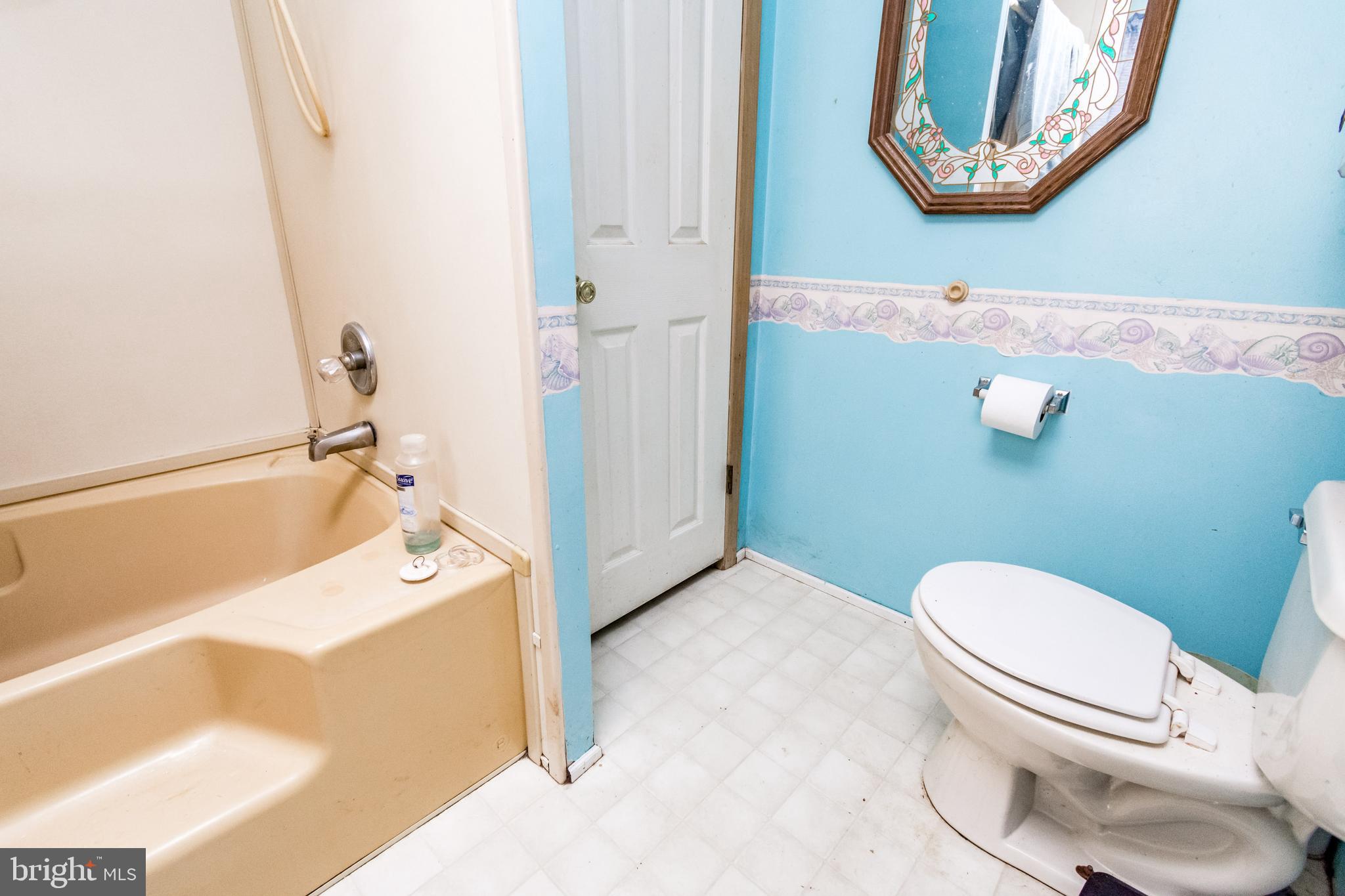 2293 Fords Corner Road Hartly, DE 19953 - Photo 35 of 47 a white toilet sitting next to a bathroom sink and a mirror