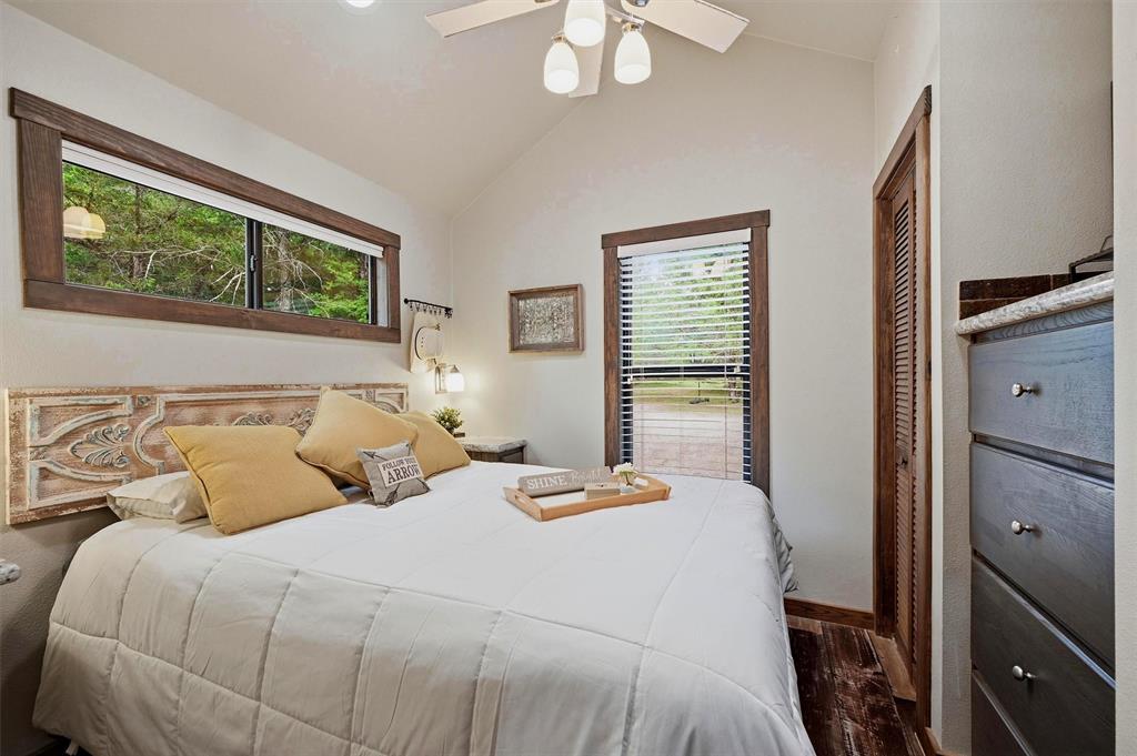 3958 Ranch Road Whitesboro, TX 76273 - Photo 19 of 40 Bedroom featuring wood-finish flooring, wood-trimmed windows, and a ceiling fan with integrated lighting