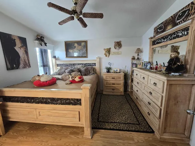 a bedroom with a bed and a flat tv screen on the dresser