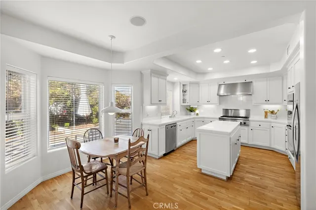 a kitchen with a sink a stove a refrigerator a center island and cabinets