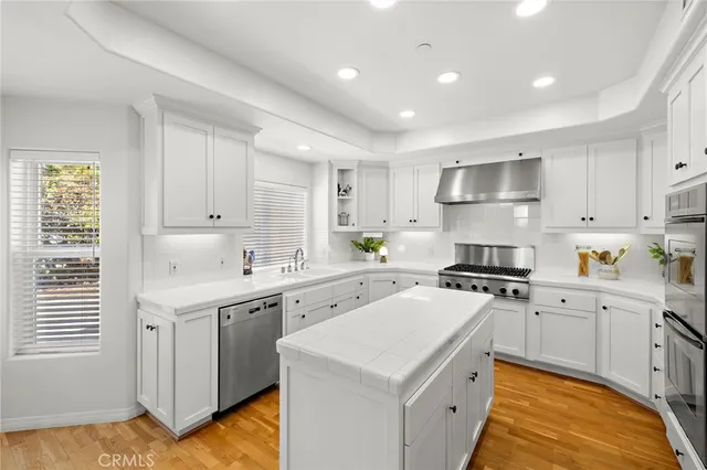 a large white kitchen with a large window