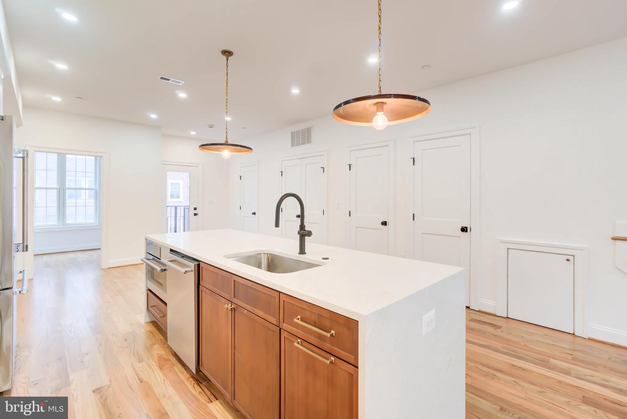 2910 18th Street Northwest Washington, DC 20009 - Photo 12 of 54 a kitchen with stainless steel appliances a sink dishwasher and white cabinets with wooden floor