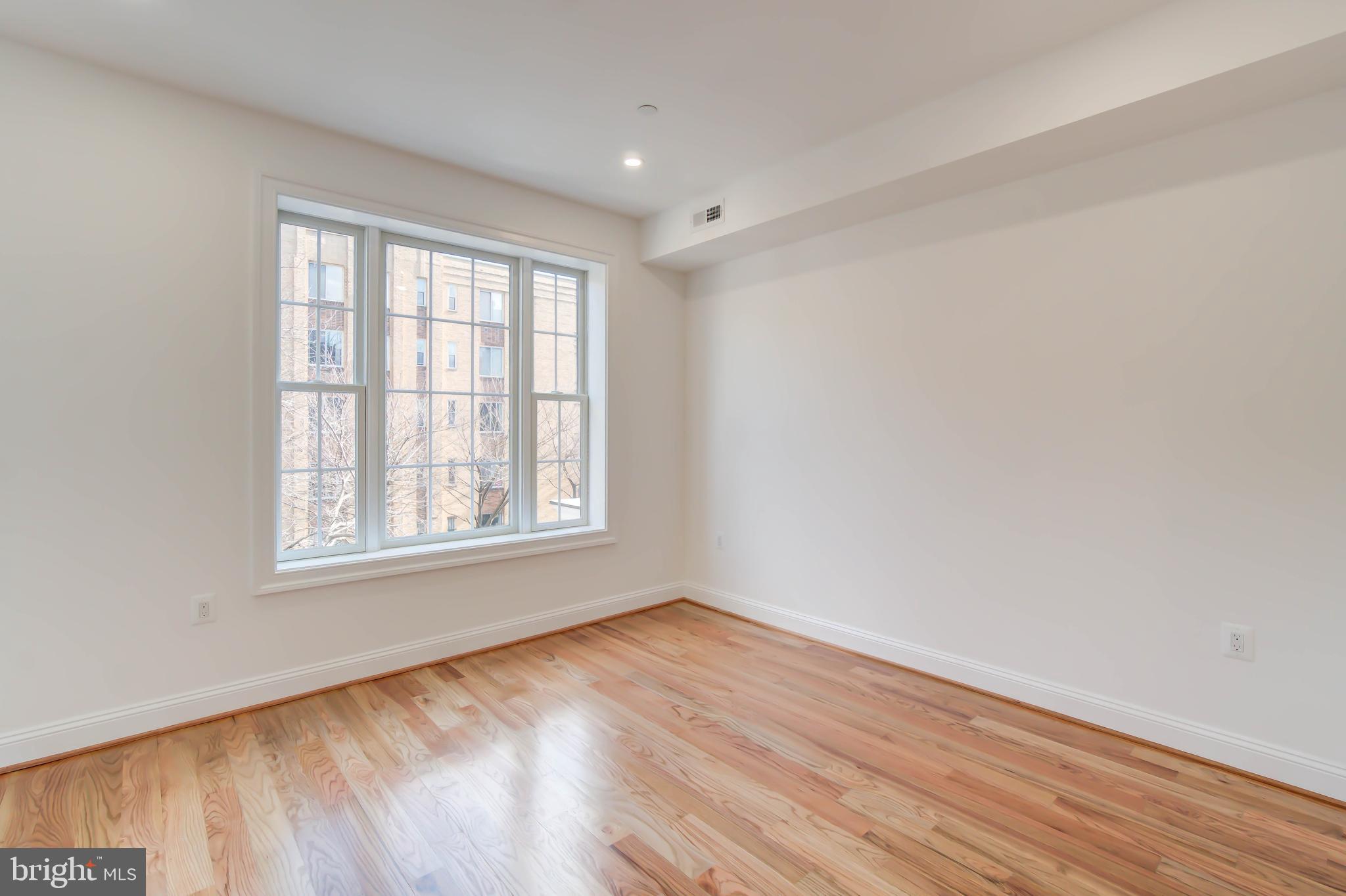2910 18th Street Northwest Washington, DC 20009 - Photo 20 of 54 an empty room with wooden floor and windows