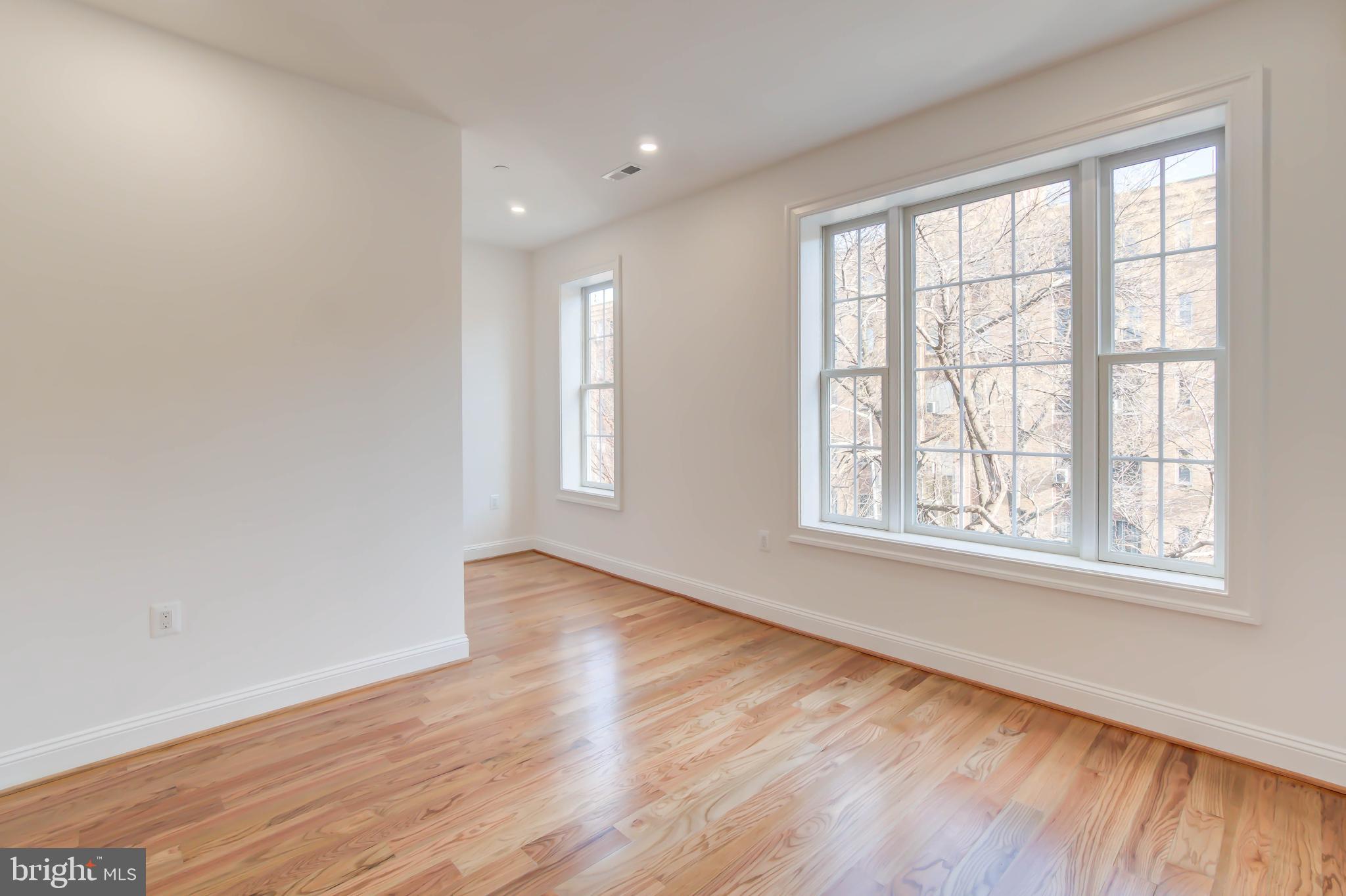 2910 18th Street Northwest Washington, DC 20009 - Photo 21 of 54 an empty room with wooden floor and windows