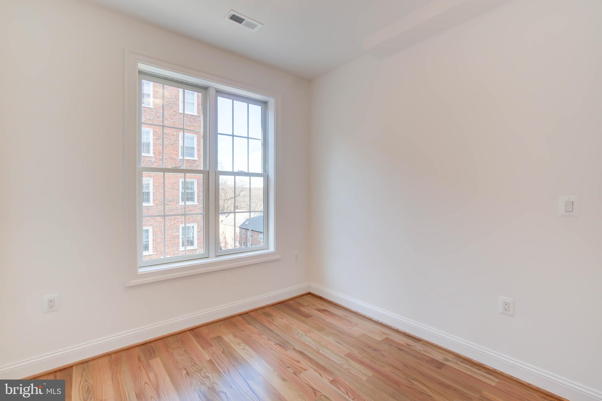 2910 18th Street Northwest Washington, DC 20009 - Photo 31 of 54 an empty room with wooden floor and windows