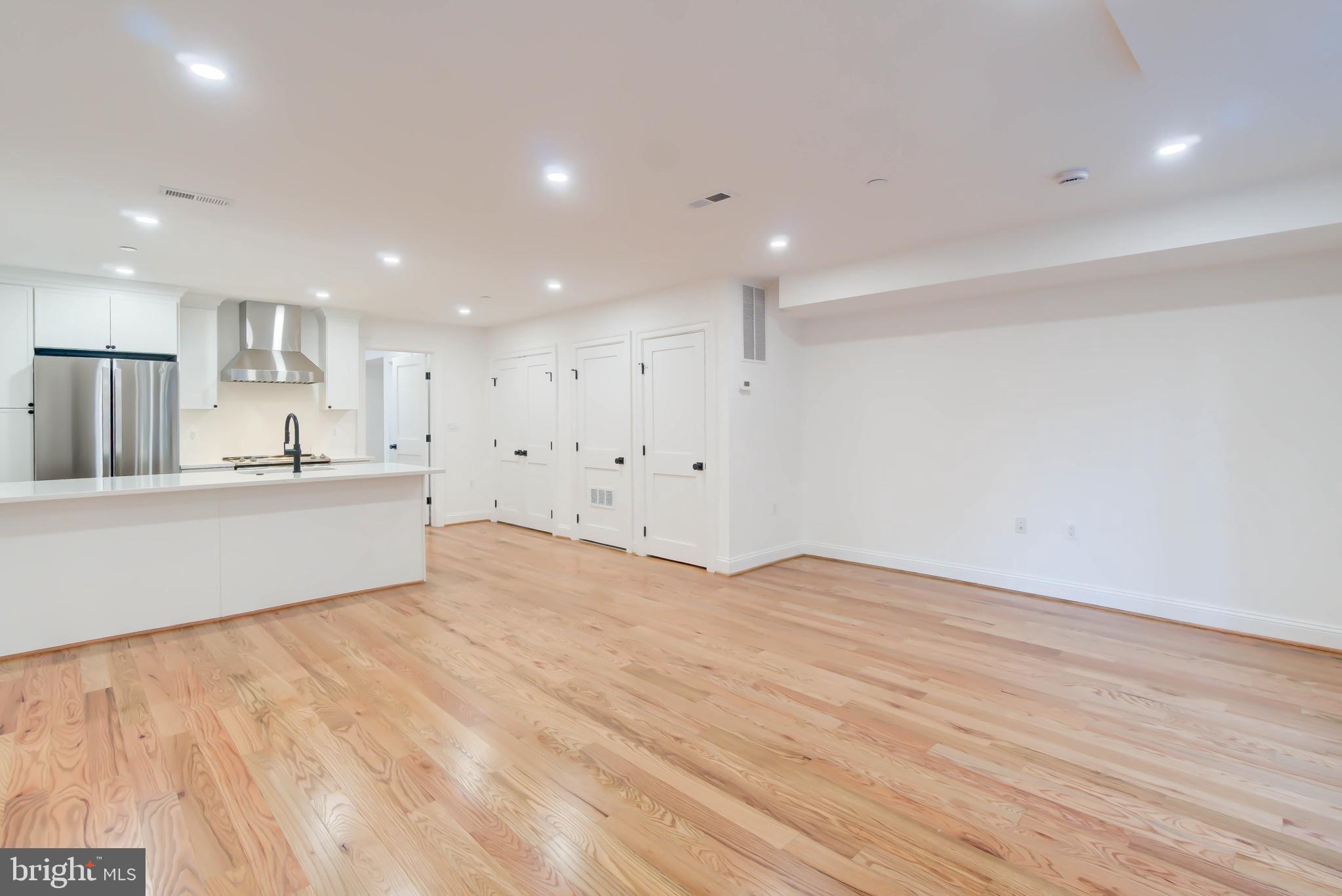 2910 18th Street Northwest Washington, DC 20009 - Photo 40 of 54 a view of an empty room with kitchen view and wooden floor