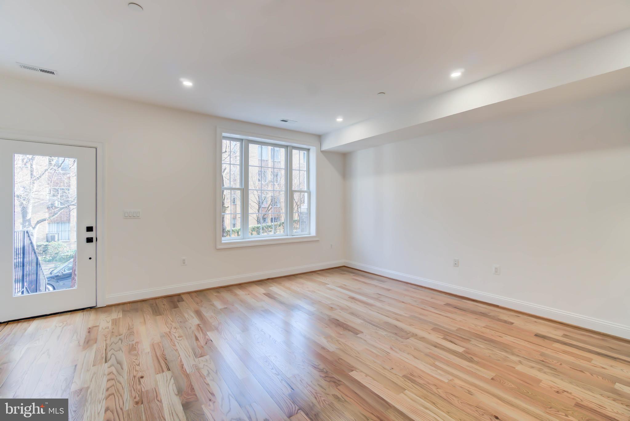 2910 18th Street Northwest Washington, DC 20009 - Photo 5 of 54 an empty room with wooden floor and windows