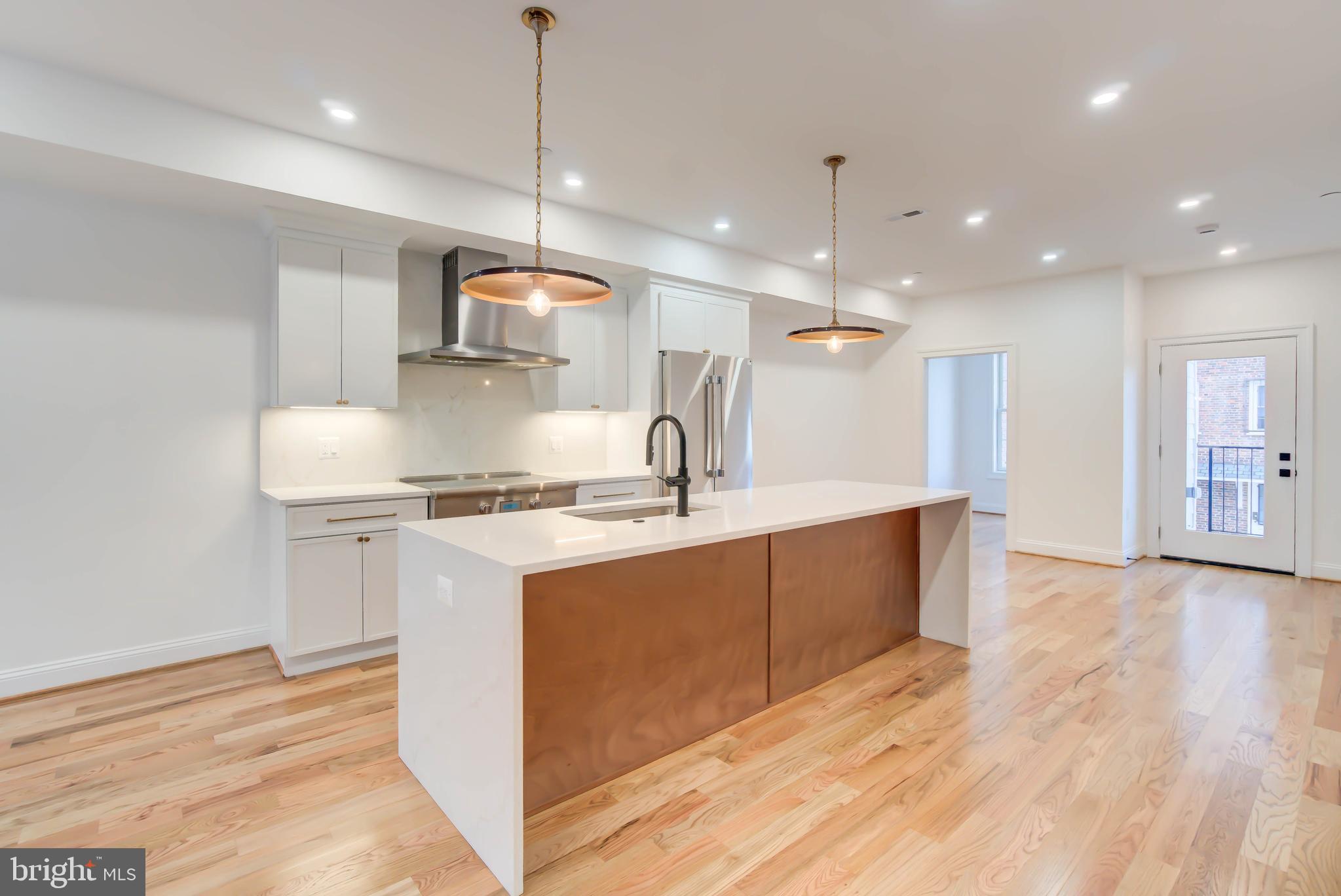 2910 18th Street Northwest Washington, DC 20009 - Photo 8 of 54 a kitchen with stainless steel appliances granite countertop a sink a stove a refrigerator and a window
