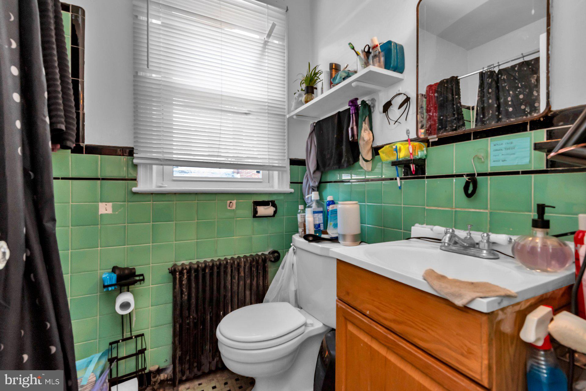 1016 Irving Street Northwest Washington, DC 20010 - Photo 26 of 37 a bathroom with a sink a toilet and a shower curtain