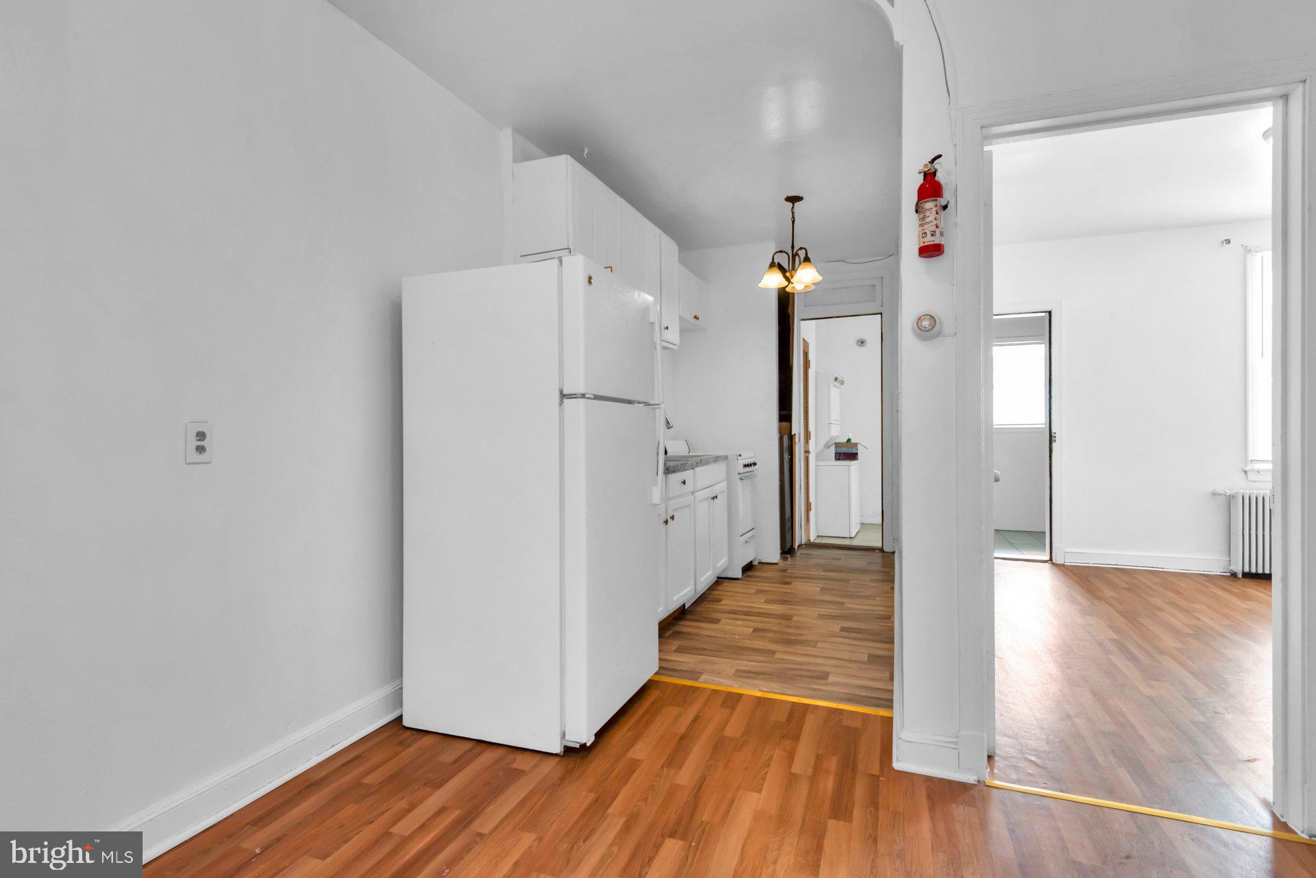 1016 Irving Street Northwest Washington, DC 20010 - Photo 8 of 37 a view of a kitchen with wooden floor and a refrigerator