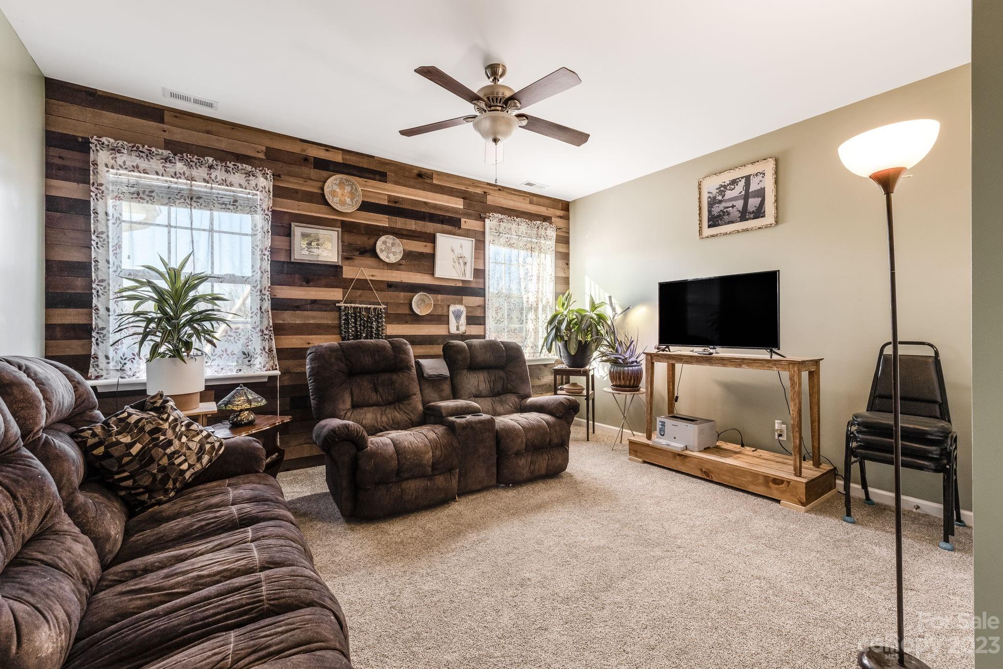 246 Roanoke Road Fletcher, NC 28732 - Photo 17 of 48 a living room with furniture a ceiling fan and a flat screen tv
