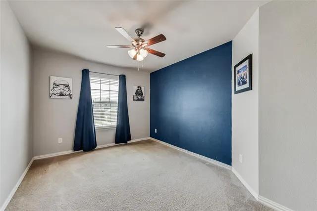 a view of a big room with windows and chandelier fan