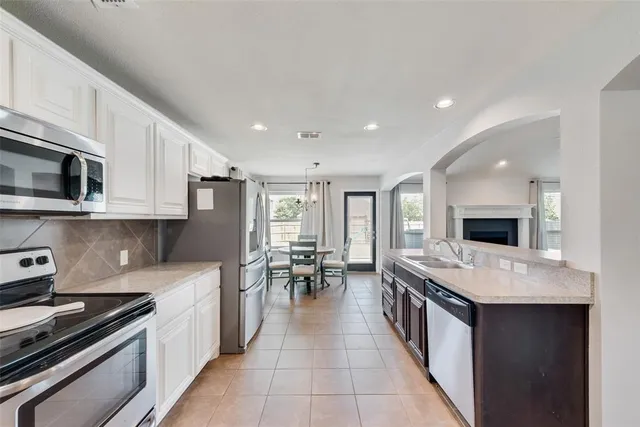 a large white kitchen with stainless steel appliances