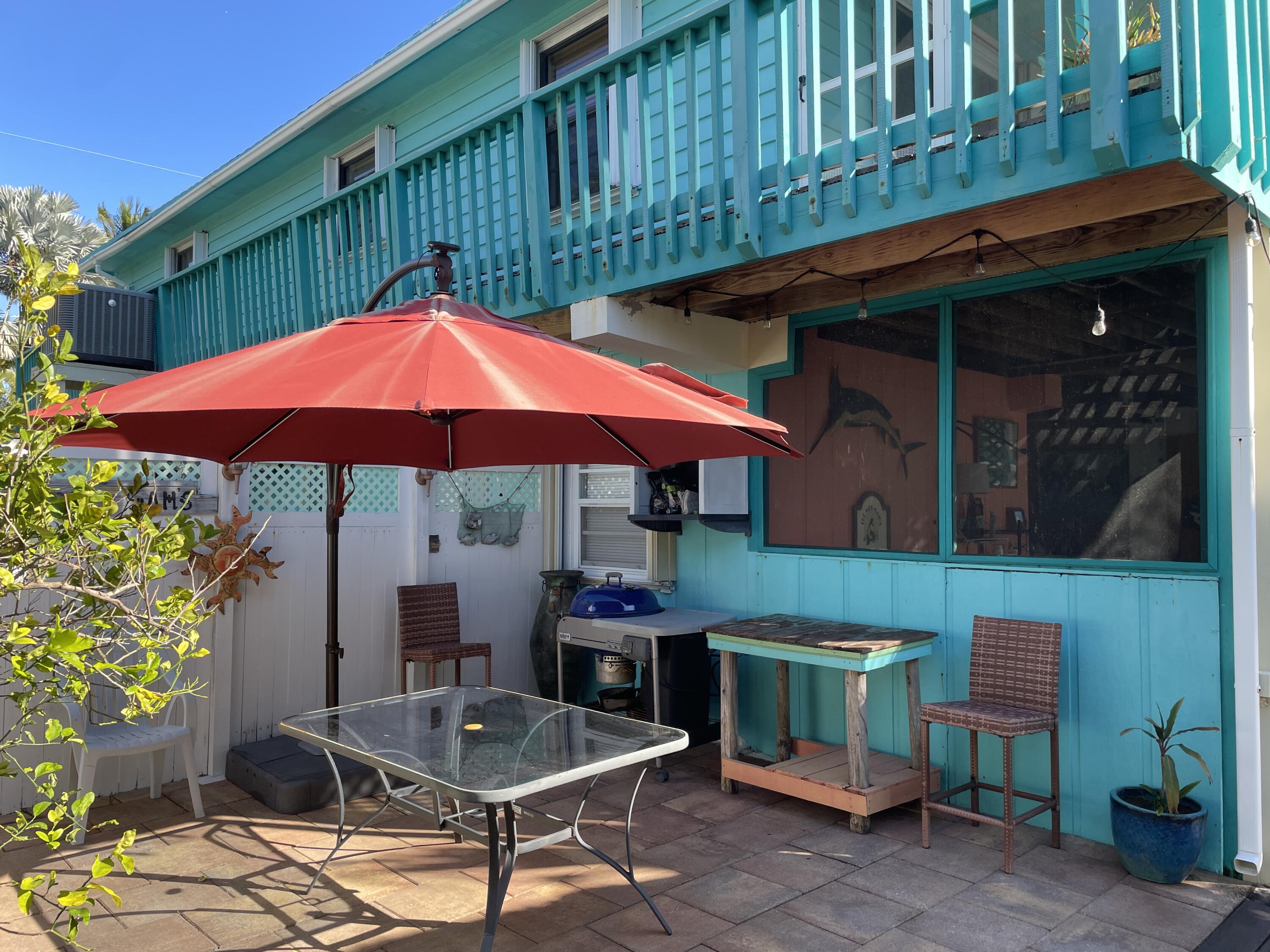 744 Blackbeard Road Summerland Key, FL 33042 - Photo 25 of 39 a patio with a table and chairs under an umbrella