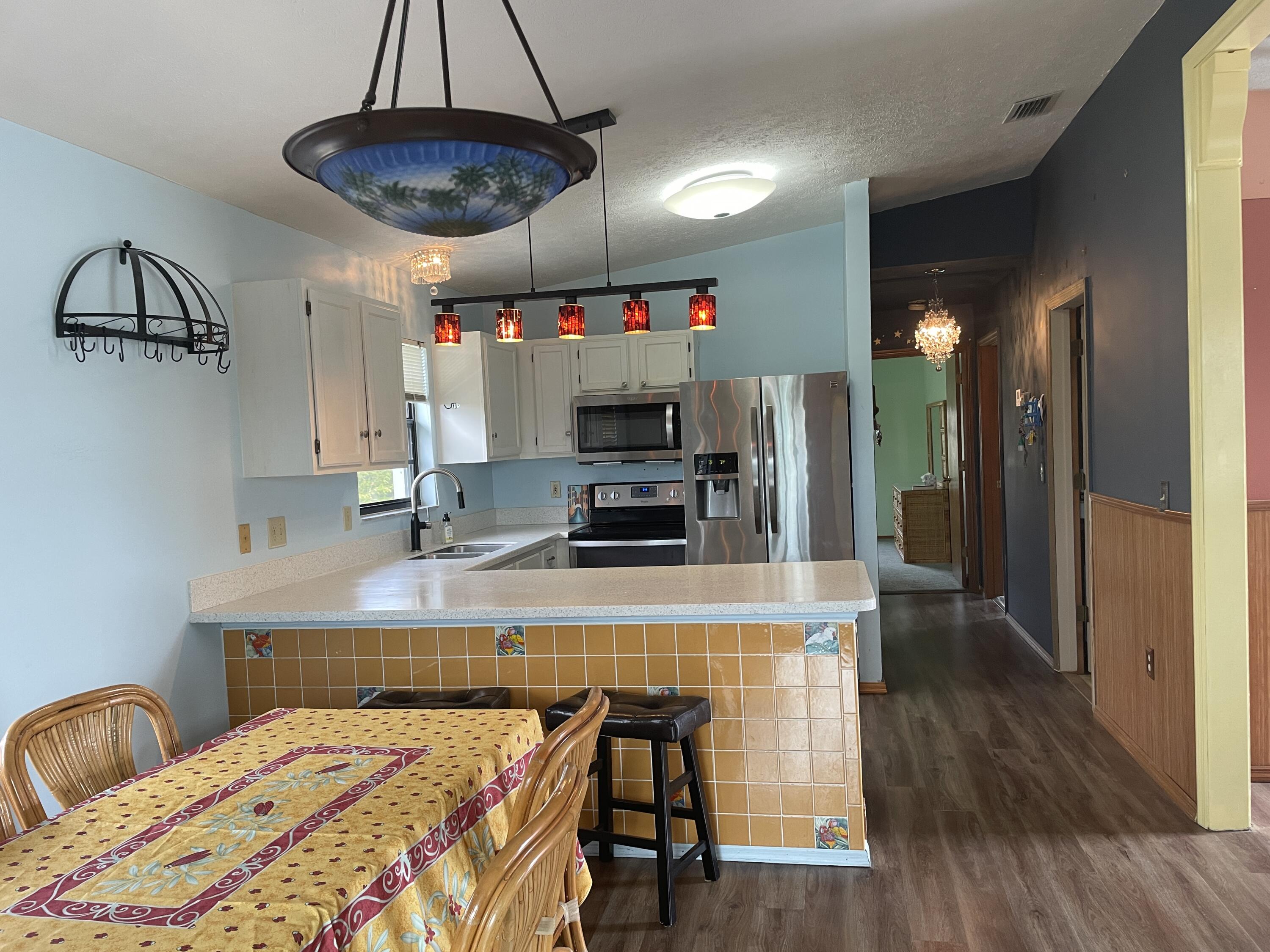 744 Blackbeard Road Summerland Key, FL 33042 - Photo 9 of 39 a kitchen with stainless steel appliances a dining table chairs stove and refrigerator