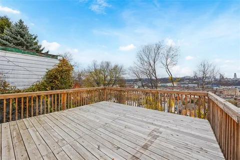 a balcony with wooden floor and city view