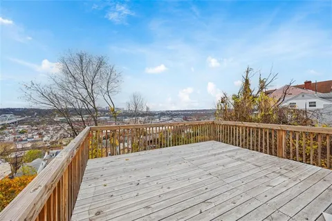 a view of balcony with wooden floor and fence