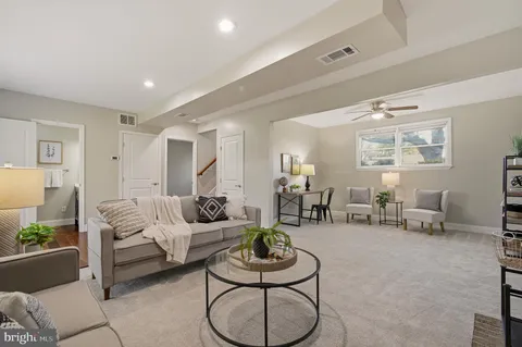 a living room with furniture potted plant and white walls