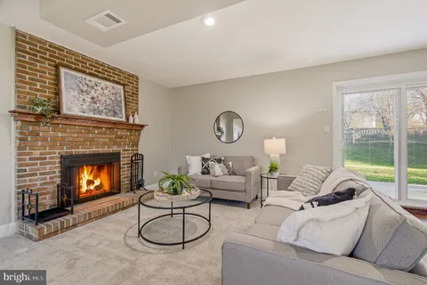 a living room with furniture a fireplace and a large window