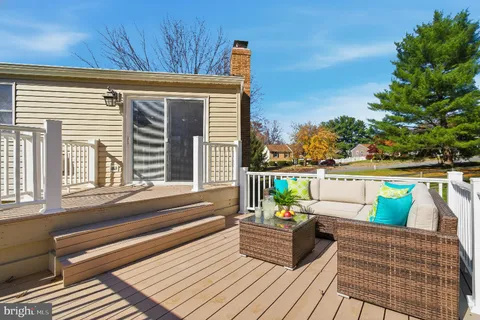a balcony with wooden floor and outdoor seating
