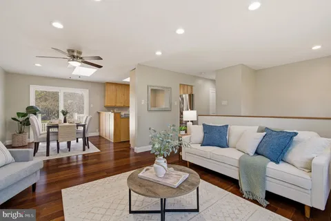 a living room with furniture and a view of kitchen