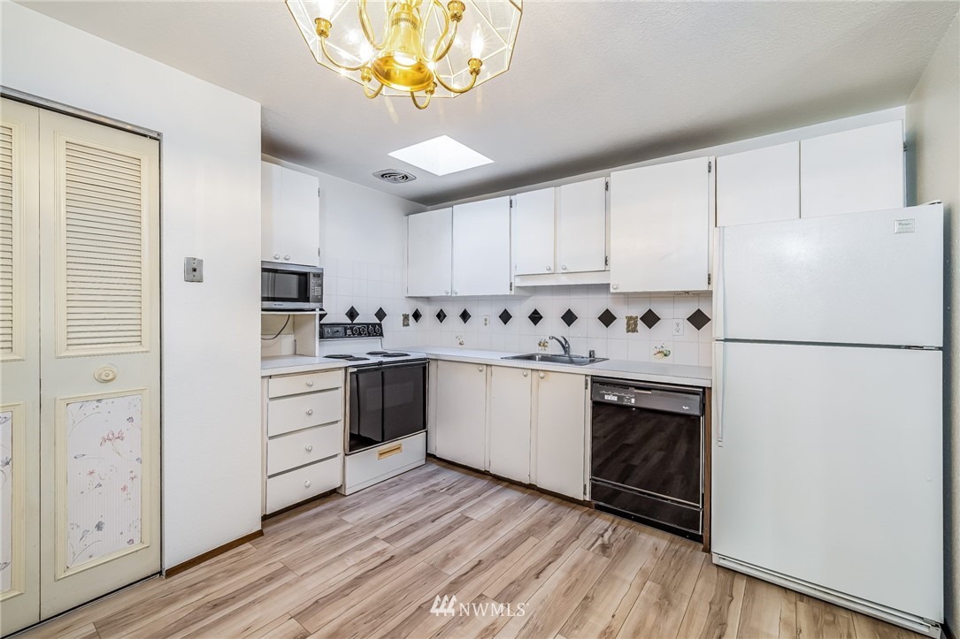 4308 Northeast Sunset Boulevard, Unit F3 Renton, WA 98059 - Photo 9 of 26 a kitchen with stainless steel appliances a refrigerator a stove a sink and white cabinets