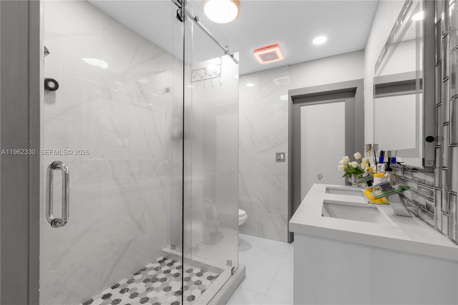 33300 Southwest 212th Avenue Homestead, FL 33034 - Photo 15 of 60 a bathroom with a sink and mirror with shower