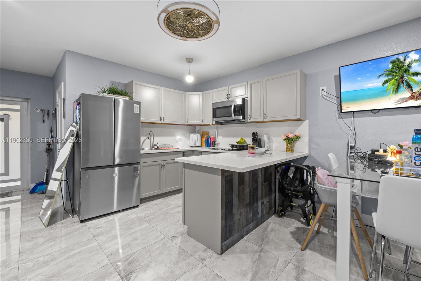 33300 Southwest 212th Avenue Homestead, FL 33034 - Photo 36 of 60 a kitchen with a refrigerator a microwave a stove and cabinets