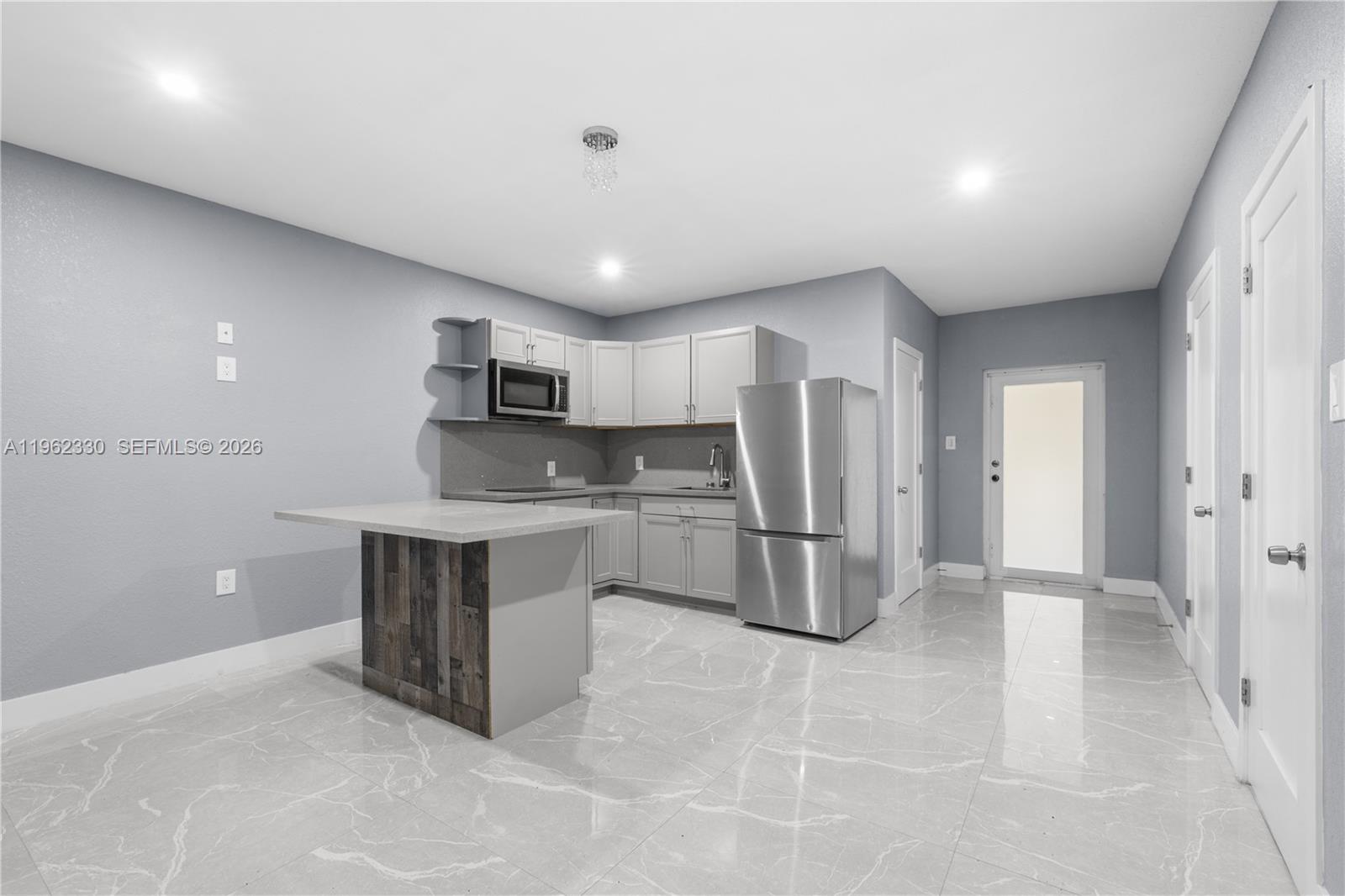 33300 Southwest 212th Avenue Homestead, FL 33034 - Photo 43 of 60 a kitchen with refrigerator and microwave