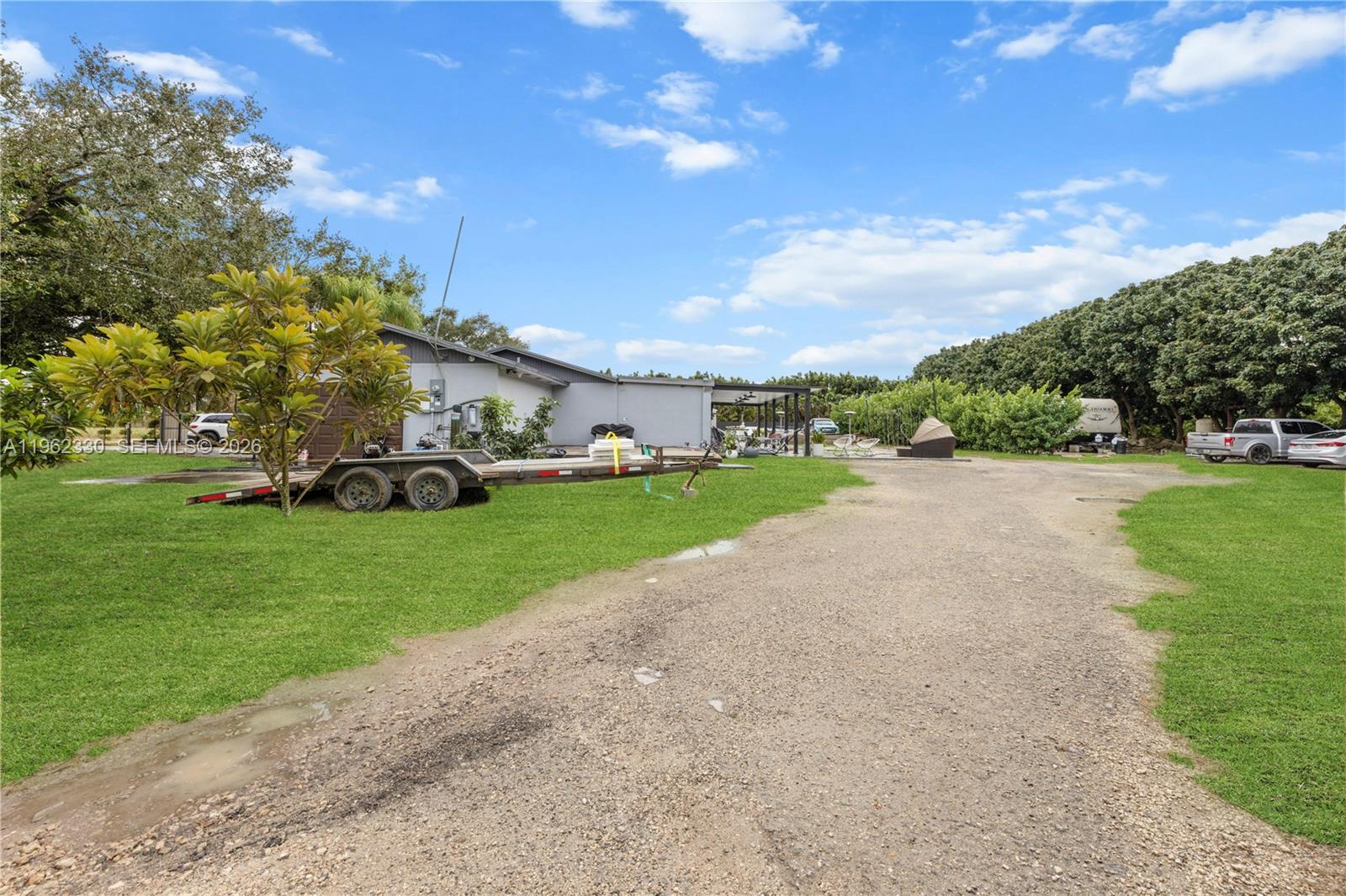 33300 Southwest 212th Avenue Homestead, FL 33034 - Photo 51 of 60 a front view of a house with a garden and trees