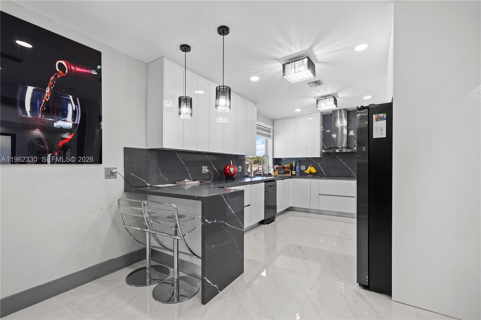 33300 Southwest 212th Avenue Homestead, FL 33034 - Photo 7 of 60 a kitchen with stainless steel appliances kitchen island granite countertop a stove a sink and a refrigerator with wooden floor