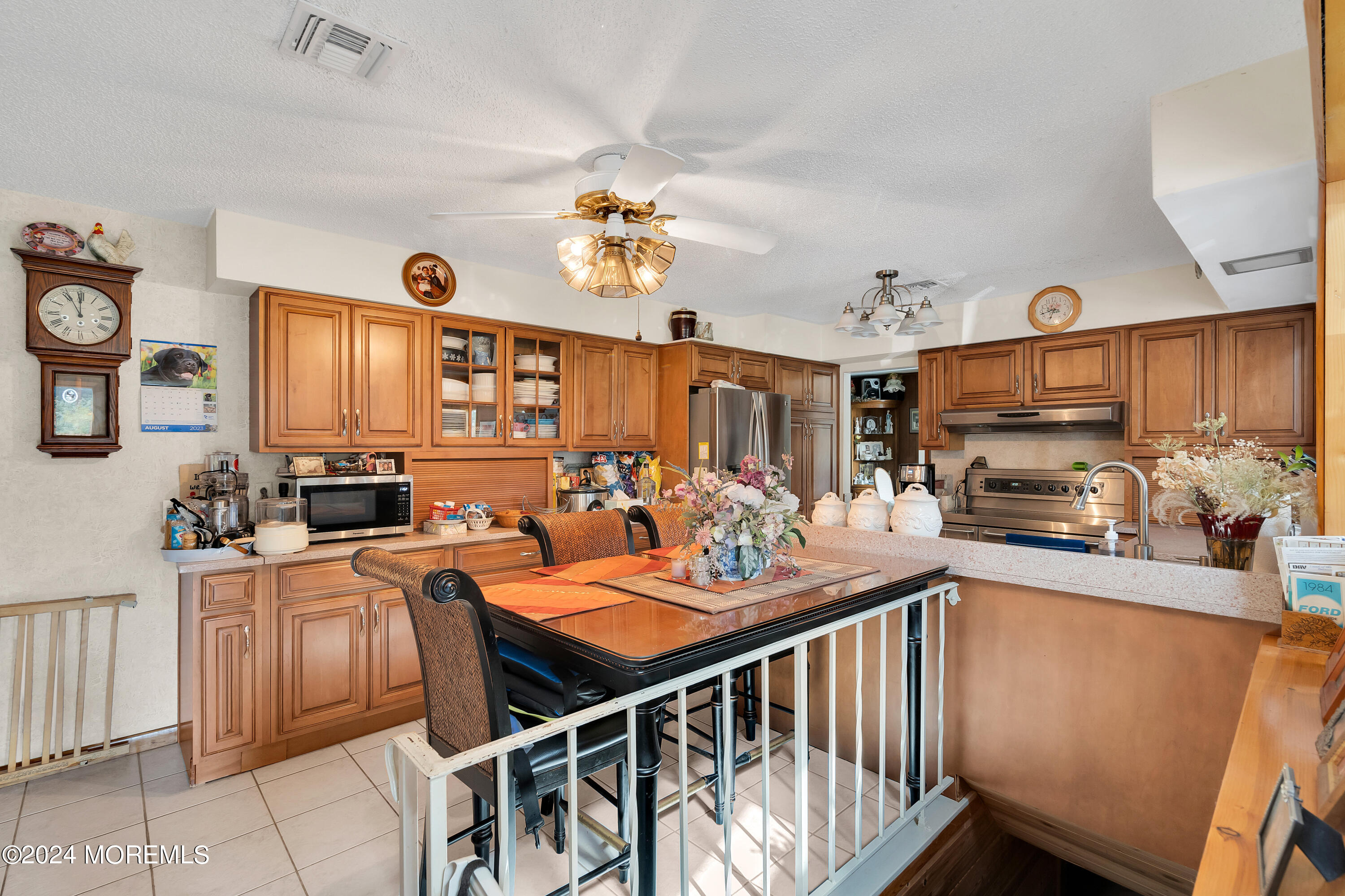 1521 Silverton Road Toms River, NJ 08755 - Photo 15 of 59 a open kitchen with stainless steel appliances granite countertop a stove top oven a sink a dining table and chairs with wooden floor