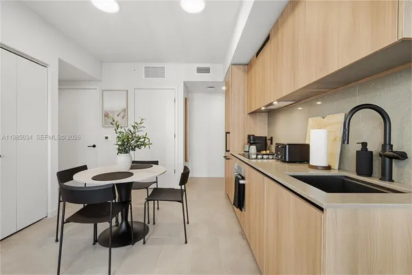 a kitchen with stainless steel appliances kitchen island a table and chairs in it